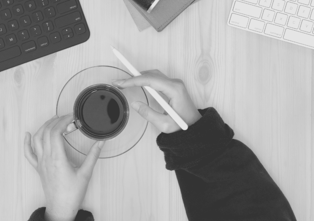 woman-holding-coffee-desk-computer